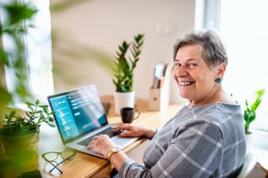 Senior woman with laptop working in home office